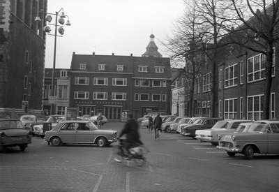 810916 Gezicht op de noordwesthoek van het Domplein te Utrecht met geparkeerde auto's.